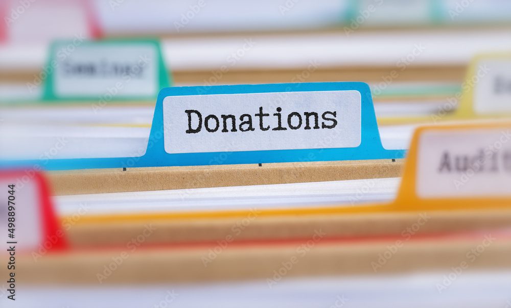 A close-up of a file organizer with labeled tabs, focusing on a blue tab labeled "Donations," reflects the meticulous care often required in Brookfield Elder Law, ensuring every detail is organized and accessible.